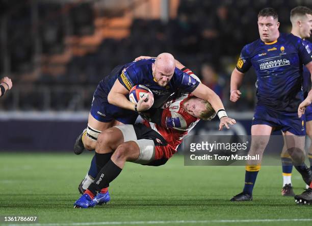 Matt Garvey of Worcester Warriors is tackled by Jack Bartlett of Gloucester Rugby during the Premiership Rugby Cup match between Worcester Warriors...