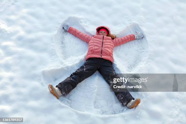 girl making snow angel - snow angel 個照片及圖片檔