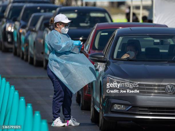 Healthcare worker conducts a test at a drive-thru COVID-19 testing site at the Dan Paul Plaza on December 29, 2021 in Miami, Florida. In response to...
