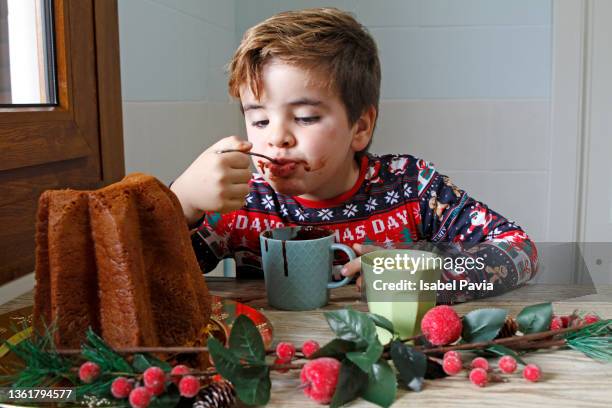 boy having breakfast during christmas morning - panettone stock pictures, royalty-free photos & images