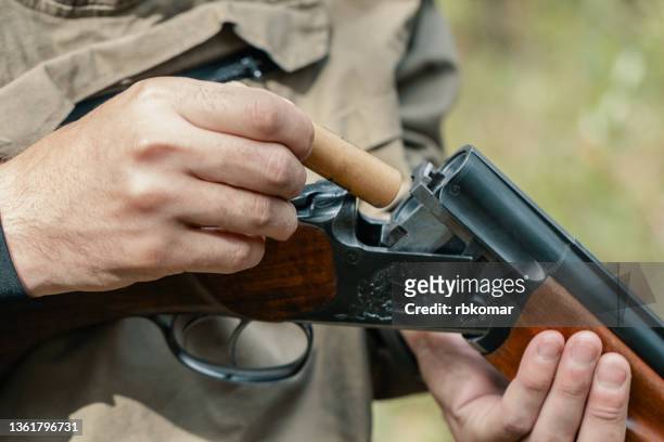 loading a bullet into a double barreled shotgun - shotgun stock pictures, royalty-free photos & images