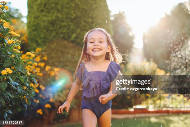 hände eines mädchens, das an einem warmen, sonnigen sommertag blaue blumen in einem strauß auf einer wiese sammelt. - young girl swimsuit stock-fotos und bilder