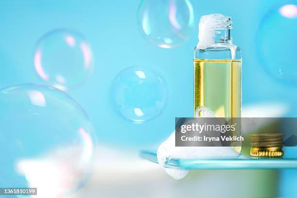 beauty product foam soap, shower gel or shampoo and  flying soap bubbles on trendy blue color  background. - froth foto e immagini stock