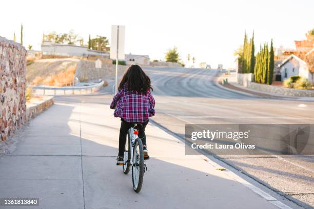 young teenage girl riding her bike in her neighborhood - el paso stock-fotos und bilder