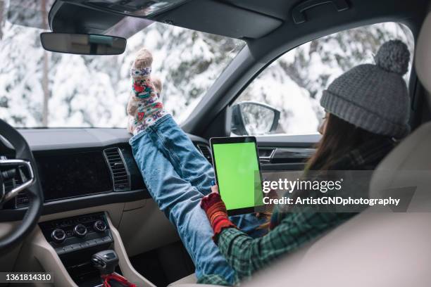 using technology while on a winter road trip - scrollen stockfoto's en -beelden