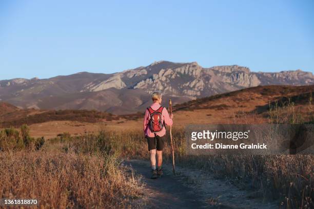 mujer mayor caminando sola por el sendero - montañas de santa mónica fotografías e imágenes de stock