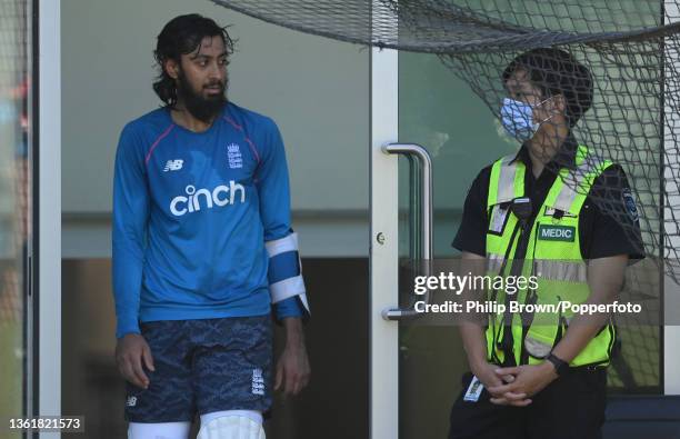 Haseeb Hameed of England walks past a mask wearing Medic during an England nets session at Melbourne Cricket Ground on December 30, 2021 in...