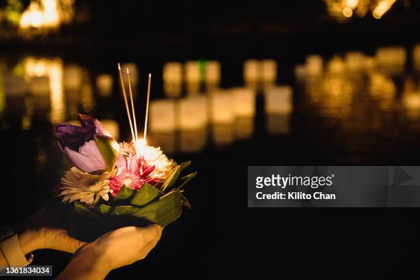 female hand holding krathong for loi krathong festival ready to put it on the river - yi peng stock pictures, royalty-free photos & images