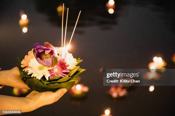 female hand holding krathong for loi krathong festival ready to put it on the river - loi krathong stockfoto's en -beelden