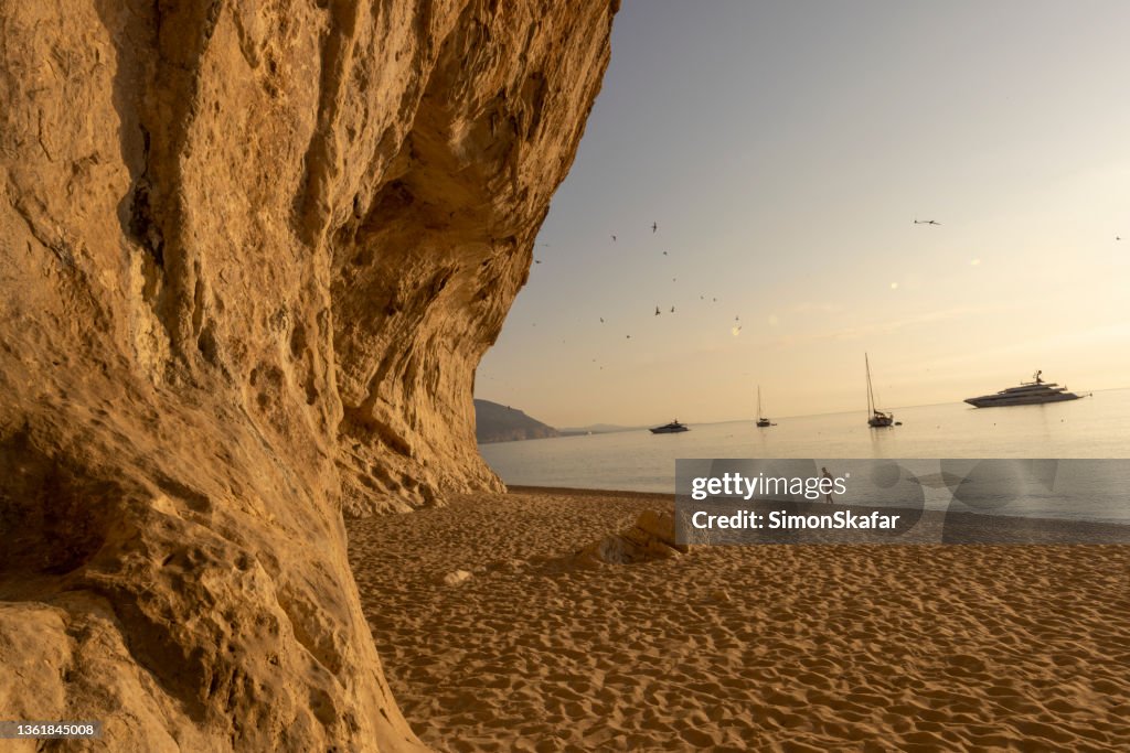 Man walking on the beach near Cala Luna cave, Sardinia, Italy.