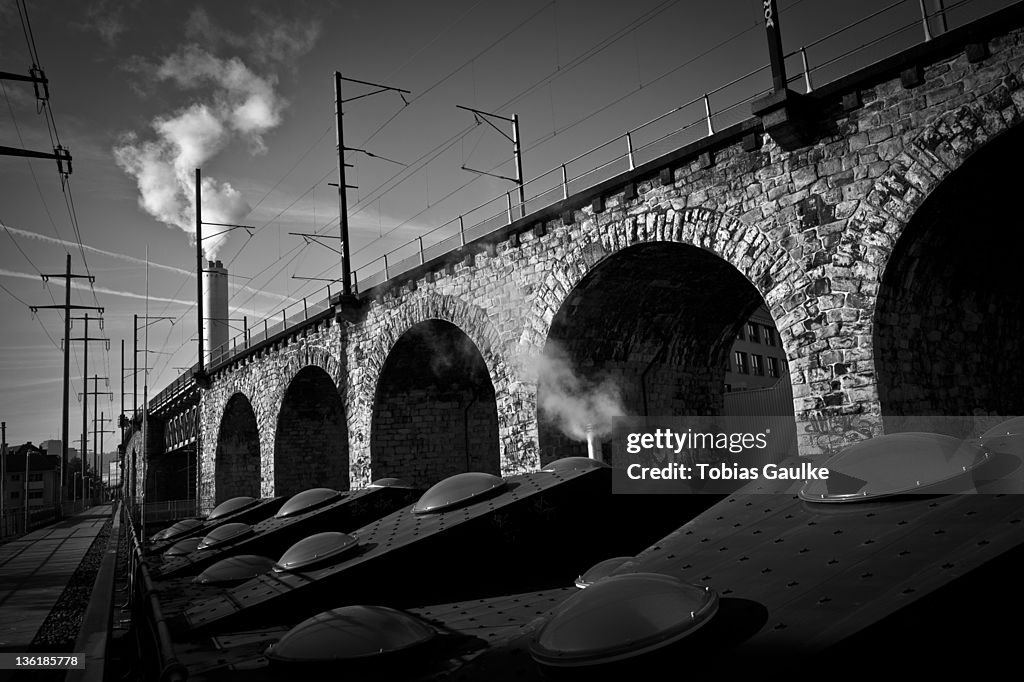 Steam machines beside bridge