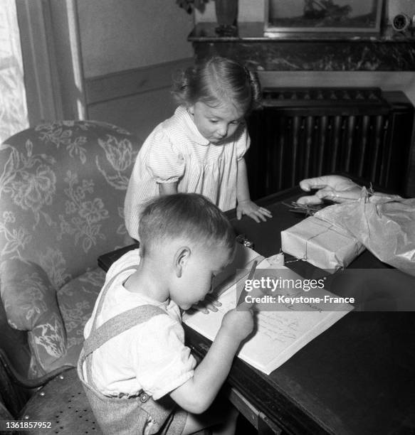 Des enfants écrivent un mots pour la fête des mères, le 13 juin 1952.