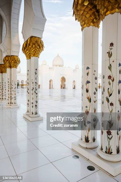 view on sheikh zayed grand mosque plateau through the embellished columns - mosque stock pictures, royalty-free photos & images