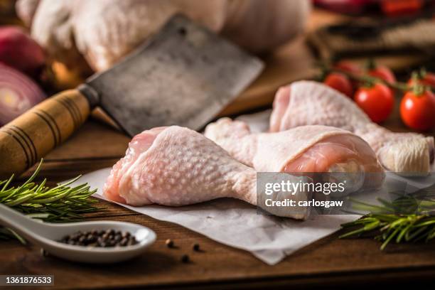 group of raw chicken legs on a rustic wooden table - chicken thigh stockfoto's en -beelden