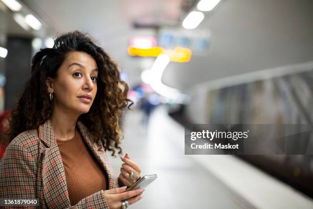 female entrepreneur with smart phone waiting for train at station - stockholm metro stock pictures, royalty-free photos & images