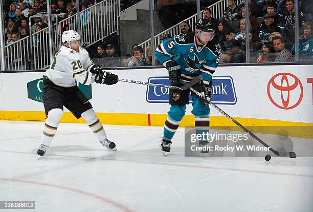 Defenseman Colin White of the San Jose Sharks skates with the puck against right wing Radek Dvorak of the Dallas Stars at the HP Pavilion on December...