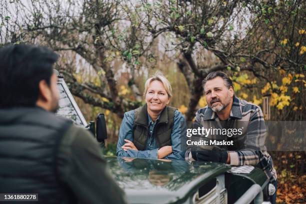 mother and father talking with son by sports utility vehicle - father in law stock pictures, royalty-free photos & images