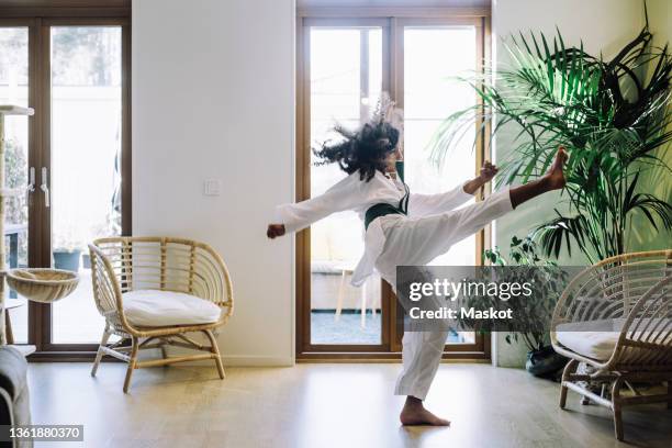 ambitious girl practicing karate in living room - karate stock pictures, royalty-free photos & images