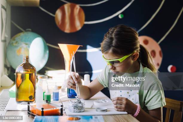 girl doing scientific experiment at table - 科学者　子供 ストックフォトと画像