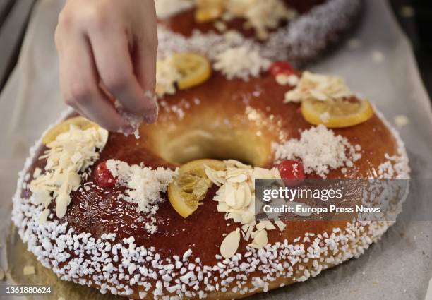 An employee decorates a 'Roscon de Reyes', in the bakery La Magdalena de Proust, on 29 December, 2021 in Madrid, Spain. The Christmas holidays come...