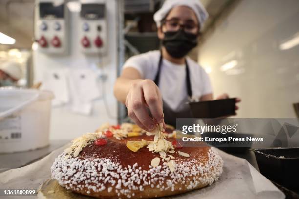 An employee decorates a 'Roscon de Reyes', in the bakery La Magdalena de Proust, on 29 December, 2021 in Madrid, Spain. The Christmas holidays come...