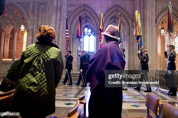 People watch as a color guard walks to the tomb of Woodrow Wilson during a wreath laying at the National Cathedral December 28, 2011 in Washington,...