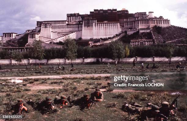 Groupe de soldats chinois allongés par terre, en arrière plan le Palais du Potala en aout 1980 à Lhassa au Tibet, Chine.