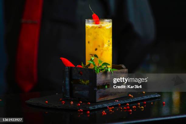 passion fruit drink with red pepper on a dark background. brazilian passion fruit caipirinha - passionfruit stock pictures, royalty-free photos & images