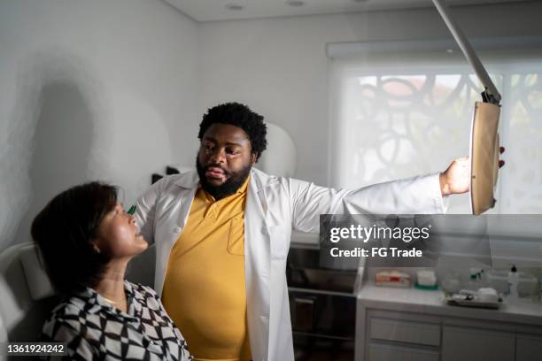 doctor examining a patient at a medical clinic - dermatologists talking to each other patient stock pictures, royalty-free photos & images