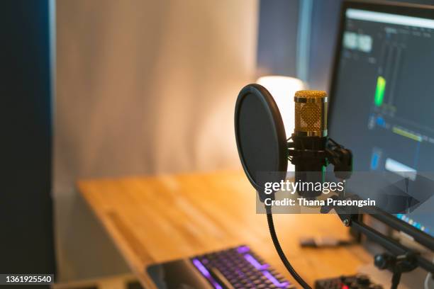 a female gamer and streamer is playing video games on her computer. focus on her mic setup. - media & entertainment stock pictures, royalty-free photos & images