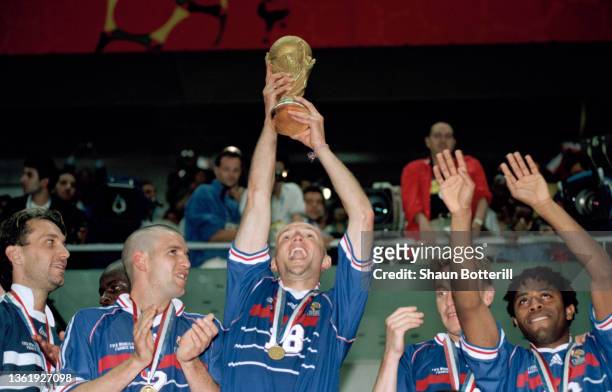 France player Frank Leboeuf holds aloft the Trophy after their 3-0 win over Brazil, flanked by Vincent Candela Stephane Guivarc'h and Bernard Diomede...