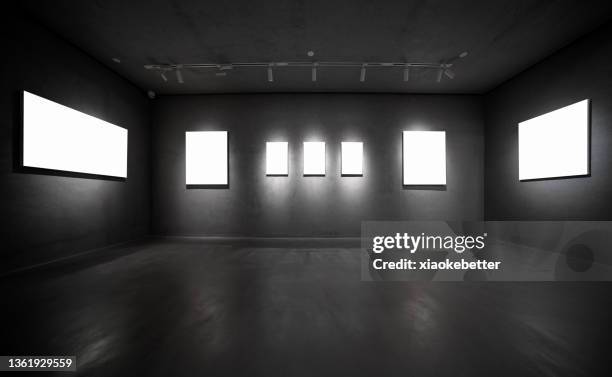 row of led screens on concrete wall in black room - dark room stock-fotos und bilder