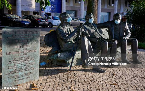 Protective masks partially cover the faces of the statues commemorating Jan Karski, Jerzy Jan Lerski and Jan Nowak-Jeziorański, Polish resistant's...