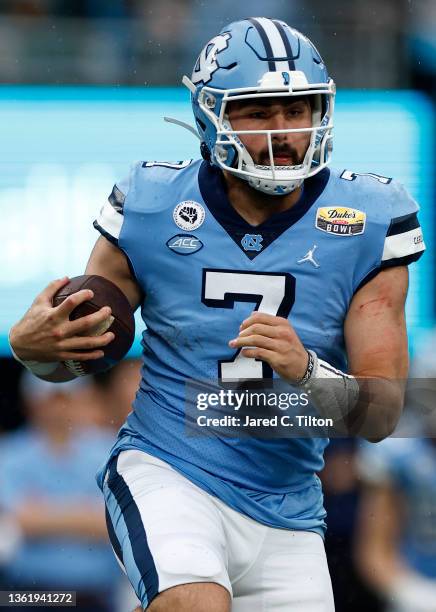 Sam Howell of the North Carolina Tar Heels scrambles outside the pocket during the first half of the Duke's Mayo Bowl against the South Carolina...