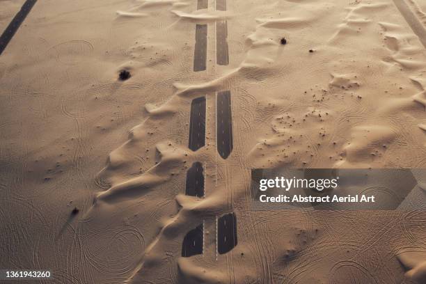 aerial perspective showing an abandoned highway crossing the desert, dubai, united arab emirates - duna - fotografias e filmes do acervo