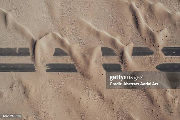 two roads in the desert covered by sand seen from directly above, dubai, united arab emirates - extreme weather desert stock pictures, royalty-free photos & images