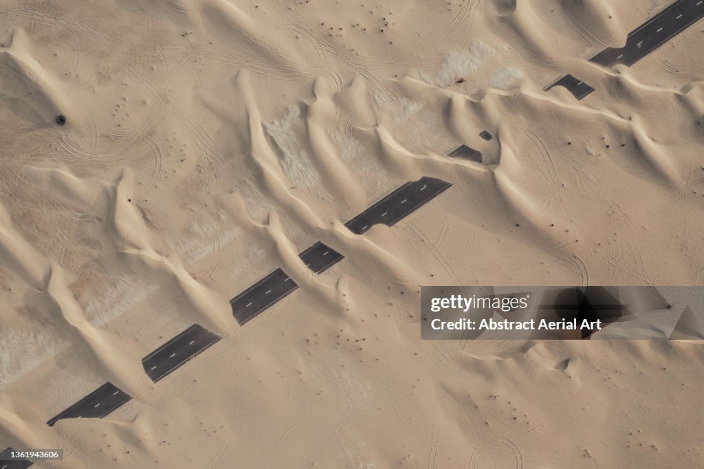 Sand dunes covering an abandoned highway in the desert, Dubai, United Arab Emirates