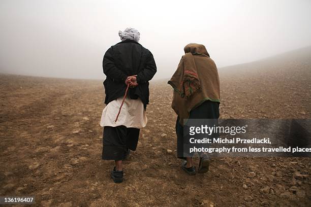 two afghans walking towards mist - go with afghanistan stock pictures, royalty-free photos & images
