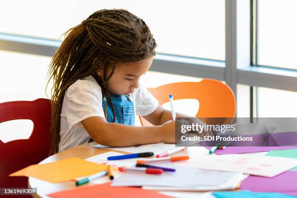niña en edad preescolar usa suministros de arte para crear dibujos - papel para manualidades fotografías e imágenes de stock