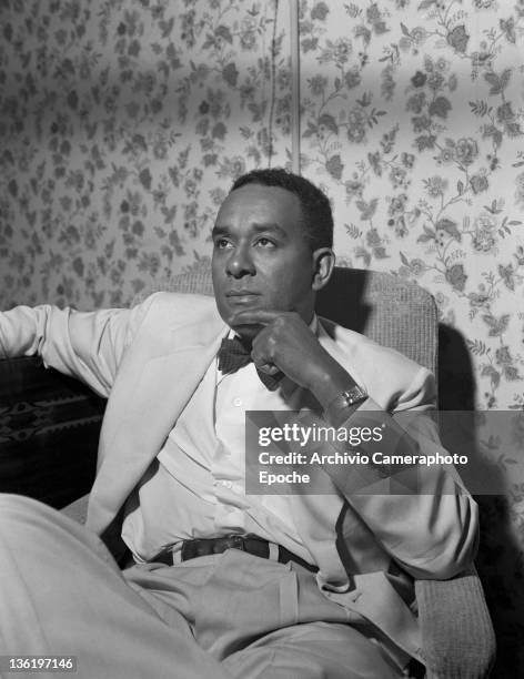 American author Richard Wright sitting on a sofa, Lido, Venice, 1950.