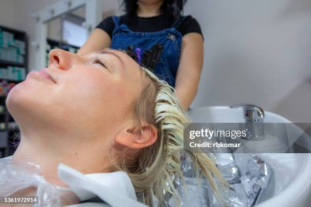 washing off hair dye in the sink after dyeing in a fashionable beauty salon close-up - hornskikt bildbanksfoton och bilder