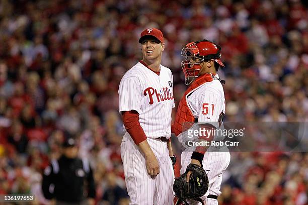 Roy Halladay and Carlos Ruiz of the Philadelphia Phillies look on from the pitcher's mound against the St. Louis Cardinals during Game Five of the...