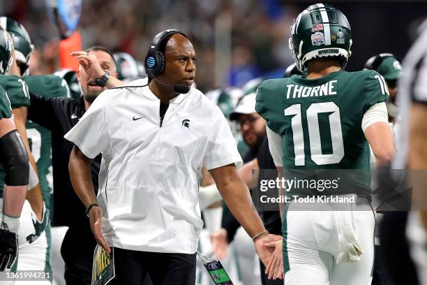 Head Coach Mel Tucker of the Michigan State Spartans hi-fives Payton Thorne of the Michigan State Spartans during the first quarter of the game...