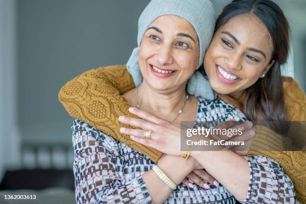 krebspatientin sitzt mit ihrer tochter draußen - indian mother daughter stock-fotos und bilder