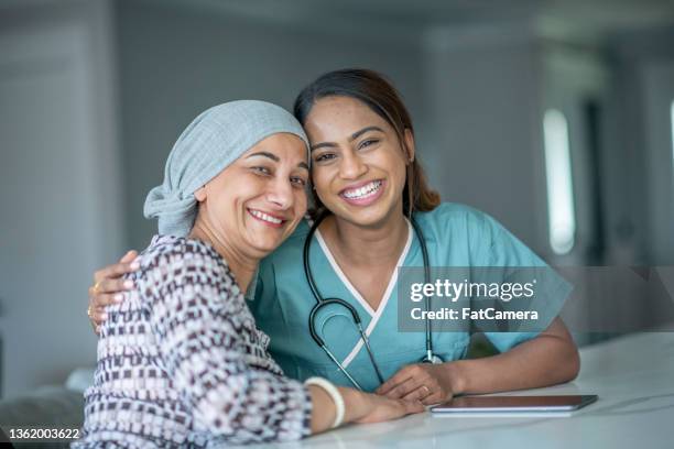 cancer patient sharing a hug with a nurse - cancer care stock pictures, royalty-free photos & images