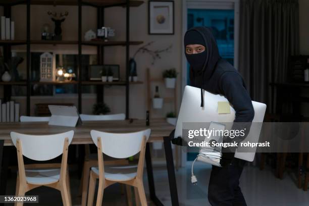 the thief stole the computer screen from the living room. - burglar carried stock pictures, royalty-free photos & images