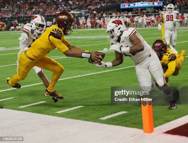 Quarterback Jayden Daniels of the Arizona State Sun Devils reaches for the end zone pylon against linebacker Darryl Peterson of the Wisconsin Badgers...