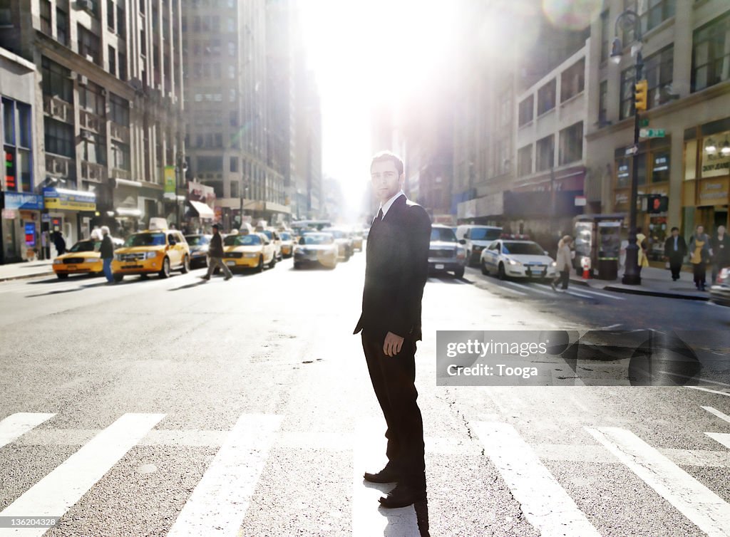 Businessman standing in the middle of busy street