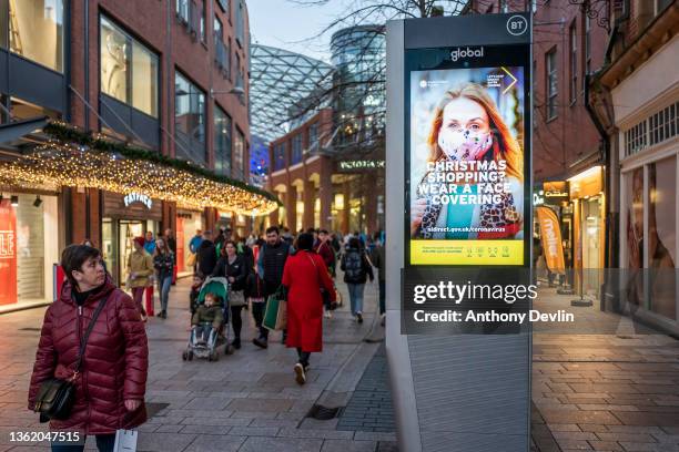 Signs advising the public to wear face coverings are displayed in the shopping district of Belfast after new restrictions were introduced in Northern...