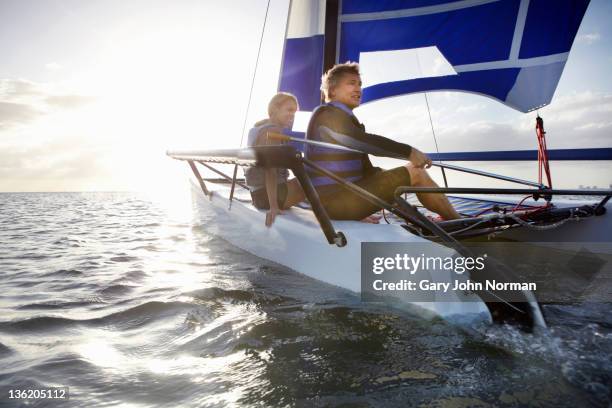 mature couple sailing small boat - catamaran race photos et images de collection